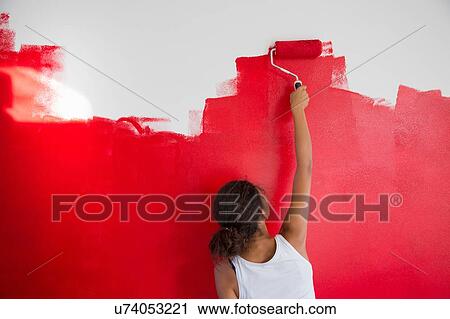 Rear view of girl painting red wall with paint roller View Large Photo Image Stock Image - Rear view of girl painting red wall with paint roller. Fotosearch