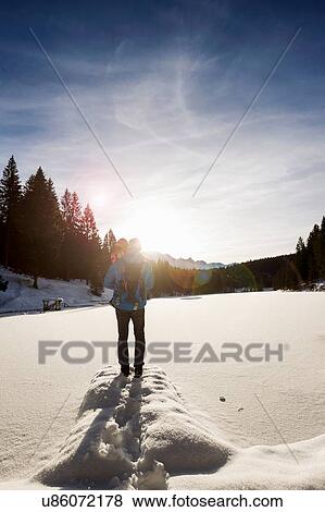 Rear view of man and toddler daughter looking out to snow covered lake, Berg, Bavaria, Germany View Large Photo Image Stock Photo - Rear view of man and toddler daughter looking out to snow covered lake, Berg, Bavaria, Germany. Fotosearch