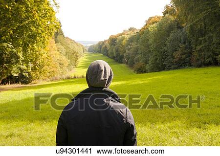 Stock Image - Rear view of man looking out at landscape, Great Missenden, Buckinghamshire, U. K. Fotosearch
