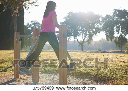 Rear view of mature woman using outdoor air walker View Large Photo Image Stock Photo - Rear view of mature woman using outdoor air walker. Fotosearch
