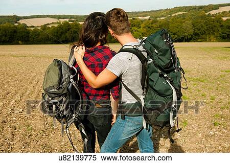 Rear view of romantic young hiking couple in field, Great Missenden, Buckinghamshire, U. K View Large Photo Image Stock Photography - Rear view of romantic young hiking couple in field, Great Missenden, Buckinghamshire, U. K. Fotosearch