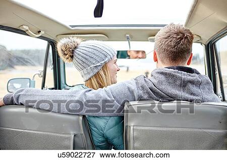 Stock Photo - Rear view of young couple in car at beach. Fotosearch