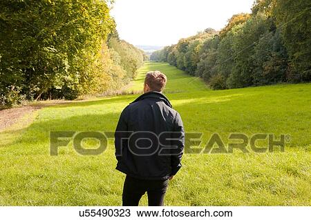 Rear view of young man looking out at landscape, Great Missenden, Buckinghamshire, U. K View Large Photo Image Stock Image - Rear view of young man looking out at landscape, Great Missenden, Buckinghamshire, U. K. Fotosearch