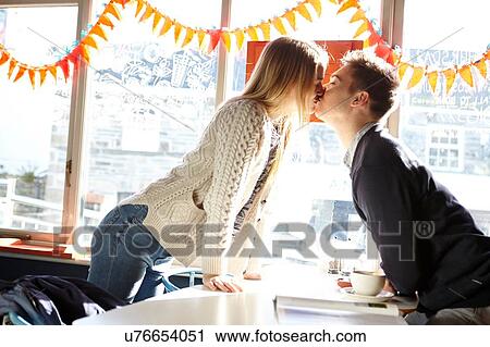 Romantic young couple kissing over in cafe table View Large Photo Image Stock Image - Romantic young couple kissing over in cafe table. Fotosearch