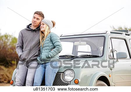 Romantic young couple leaning against car at beach View Large Photo Image Stock Image - Romantic young couple leaning against car at beach. Fotosearch