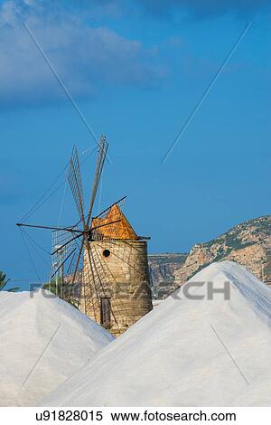 Stock Photography - Salt stacks and traditional windmill, Trapani, Sicily, Italy. Fotosearch