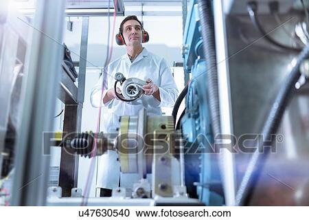 Stock Image - Scientist in turbo charger automotive research laboratory. Fotosearch