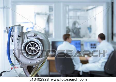 Stock Photo - Scientists working at computers in turbo charger automotive research laboratory. Fotosearch