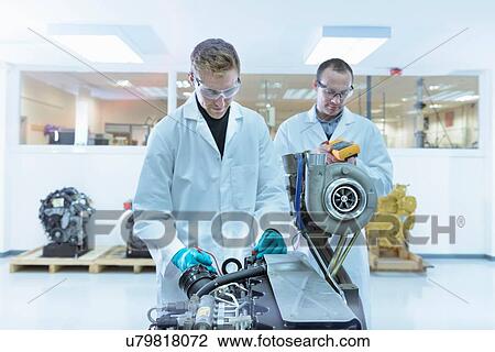 Stock Image - Scientists working in turbo charger automotive research laboratory. Fotosearch