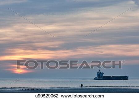 Ship and two people silhouetted on Crosby beach at sunset, Merseyside, England View Large Photo Image Stock Image - Ship and two people silhouetted on Crosby beach at sunset, Merseyside, England. Fotosearch