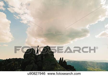 Silhouetted teenage male hiker on top of rugged rock formation, Russia View Large Photo Image Stock Photograph - Silhouetted teenage male hiker on top of rugged rock formation, Russia. Fotosearch