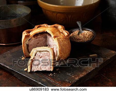 Sliced Melton Mowbray pork pie with wholegrain mustard on wooden cutting board View Large Photo Image Stock Image - Sliced Melton Mowbray pork pie with wholegrain mustard on wooden cutting board. Fotosearch