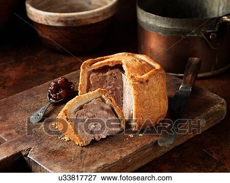 Sliced Melton Mowbray pork pie with spoonful of pickle on wooden cutting board View Large Photo Image Stock Photo - Sliced Melton Mowbray pork pie with spoonful of pickle on wooden cutting board. Fotosearch