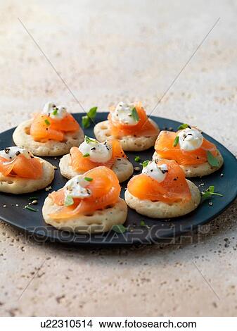 Picture - Smoked salmon and cream cheese on blinis with chive and black pepper garnish. Fotosearch