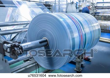 Picture - Spinning roll of printed packaging in food packaging printing factory. Fotosearch
