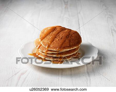 Stock Photo - Stack of pancakes drizzled with butterscotch sauce. Fotosearch