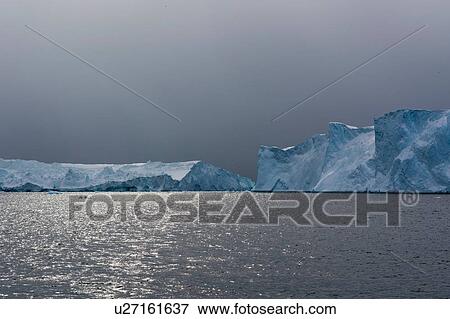 Storm clouds and icebergs at Ilulissat icefjord, Disko Bay, Greenland View Large Photo Image Stock Photo - Storm clouds and icebergs at Ilulissat icefjord, Disko Bay, Greenland. Fotosearch