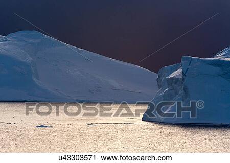 Stock Image - Storm clouds over icebergs in Ilulissat icefjord, Disko Bay, Greenland. Fotosearch