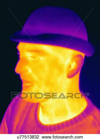 Stock Image - Thermal image of young man wearing face mask and hat. Fotosearch