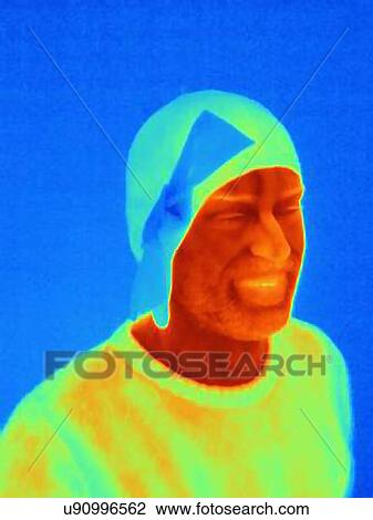 Stock Image - Thermal image of young man wearing face mask and cap with ribbon. Fotosearch
