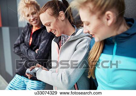Three female runners checking time in city underpass View Large Photo Image Stock Photo - Three female runners checking time in city underpass. Fotosearch