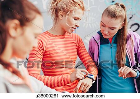 Three female runners checking time on smartwatch View Large Photo Image Stock Image - Three female runners checking time on smartwatch. Fotosearch