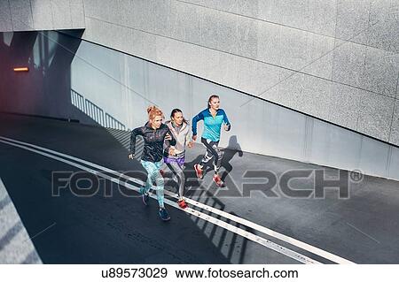Three female runners racing up city underpass View Large Photo Image Stock Photo - Three female runners racing up city underpass. Fotosearch