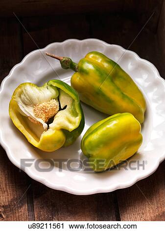 Stock Image - Three green and yellow peppers in a bowl. Fotosearch