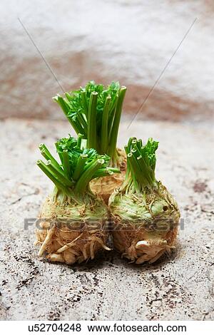 Stock Photo - Three whole celeriac with fresh green leaves. Fotosearch