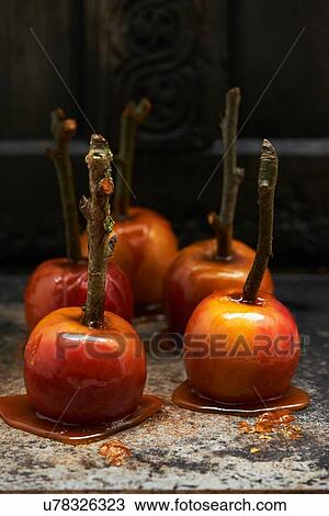 Stock Image - Toffee apples on sticks hardening on marble surface. Fotosearch