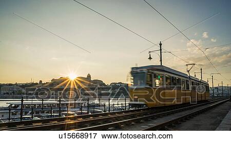 Stock Photo - Tram at sunset along the Danube, Hungary, Budapest. Fotosearch