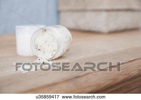 Stock Photo - Tub of bath salts spilling on dresser. Fotosearch