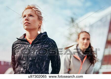 Stock Photography - Two female runners preparing for run in city. Fotosearch
