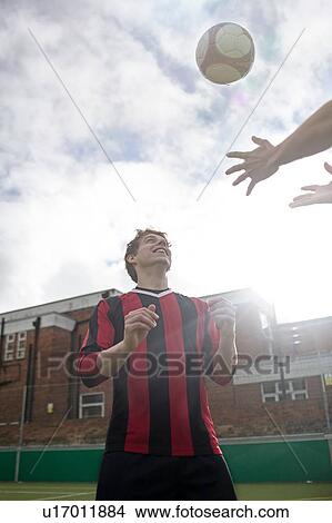 Two young men playing with football on urban football pitch View Large Photo Image Picture - Two young men playing with football on urban football pitch. Fotosearch