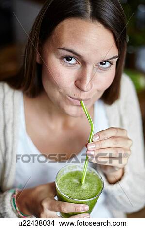 Woman drinking green smoothie with straw View Large Photo Image Picture - Woman drinking green smoothie with straw. Fotosearch