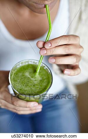 Woman drinking green smoothie with straw View Large Photo Image Stock Image - Woman drinking green smoothie with straw. Fotosearch