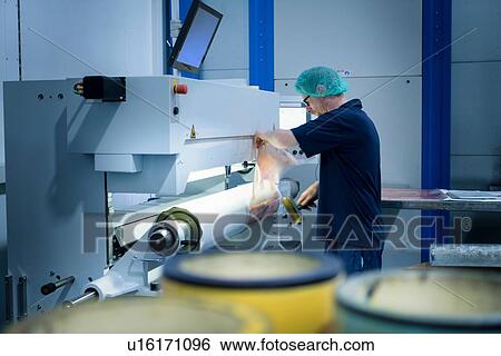 Stock Photograph - Worker preparing printing plates in food packaging printing factory. Fotosearch