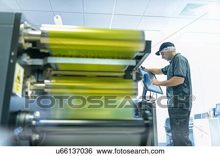 Worker with ink jet printer in food packaging printing factory View Large Photo Image Stock Photograph - Worker with ink jet printer in food packaging printing factory. Fotosearch