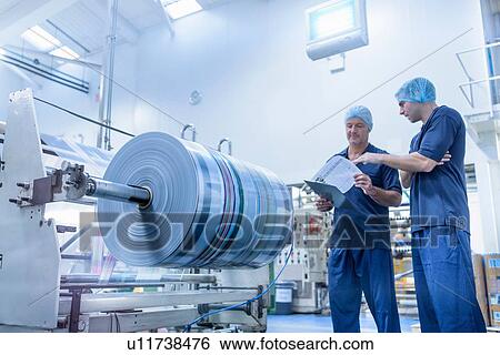 Stock Photograph - Workers in discussion in food packaging printing factory. Fotosearch