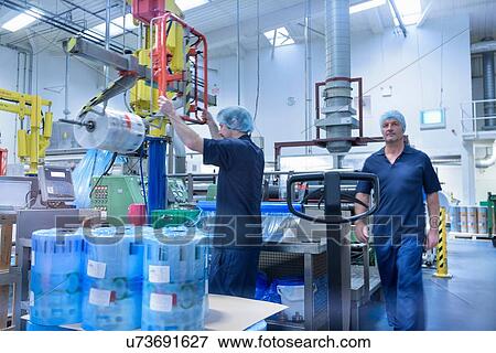Stock Photo - Workers in food packaging printing factory. Fotosearch