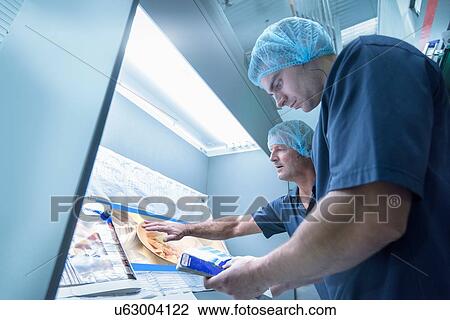 Workers inspecting printed material in food packaging printing factory View Large Photo Image Stock Image - Workers inspecting printed material in food packaging printing factory. Fotosearch