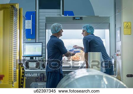 Stock Photography - Workers inspecting printed material in food packaging printing factory. Fotosearch