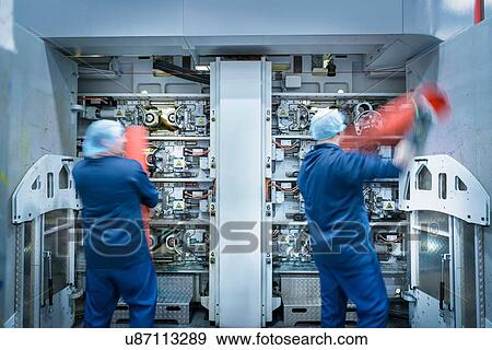 Workers loading printing plates into printer in food packaging printing factory View Large Photo Image Stock Photo - Workers loading printing plates into printer in food packaging printing factory. Fotosearch
