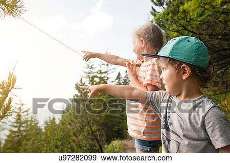 Stock Photo - Young boy and girl, outdoors, pointing. Fotosearch