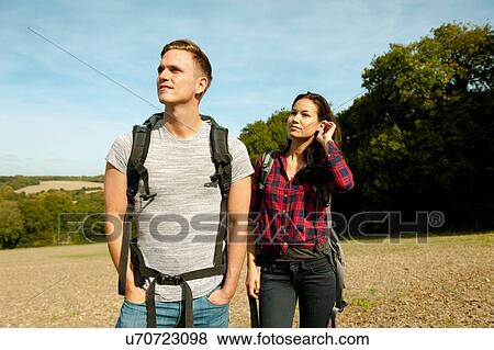 Stock Photo - Young couple hiking in field, Great Missenden, Buckinghamshire, U. K. Fotosearch