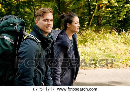 Young couple hiking on rural road View Large Photo Image Stock Photo - Young couple hiking on rural road. Fotosearch