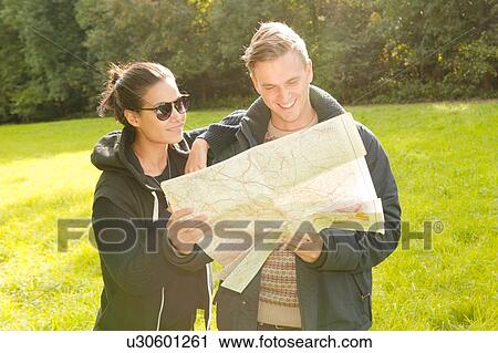 Young couple reading map in field View Large Photo Image Stock Image - Young couple reading map in field. Fotosearch