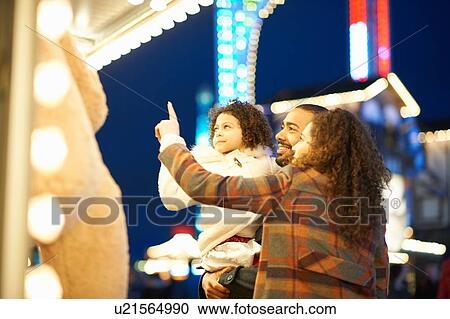 Stock Image - Young family enjoying funfair. Fotosearch