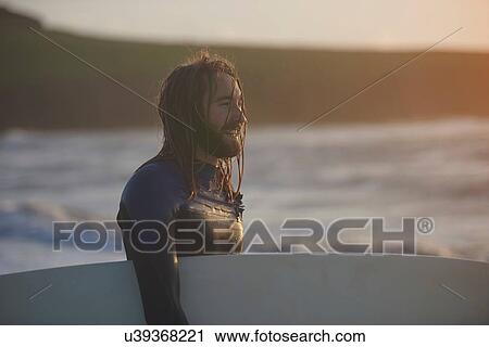 Young male surfer carrying surfboard, Devon, England, UK View Large Photo Image Stock Image - Young male surfer carrying surfboard, Devon, England, UK. Fotosearch
