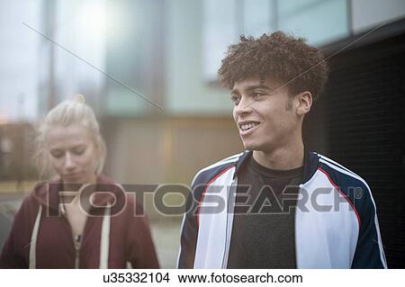 Young man and woman walking in street View Large Photo Image Picture - Young man and woman walking in street. Fotosearch